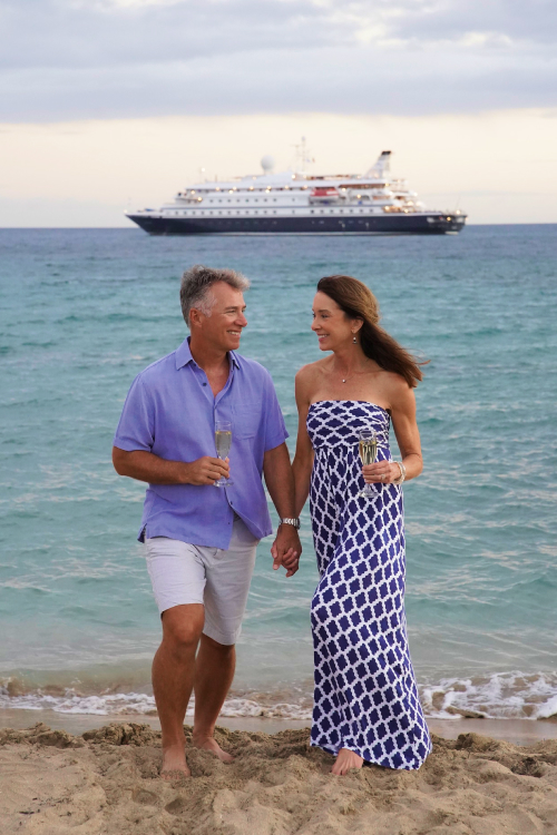 Couple walking on the beach with champagne.